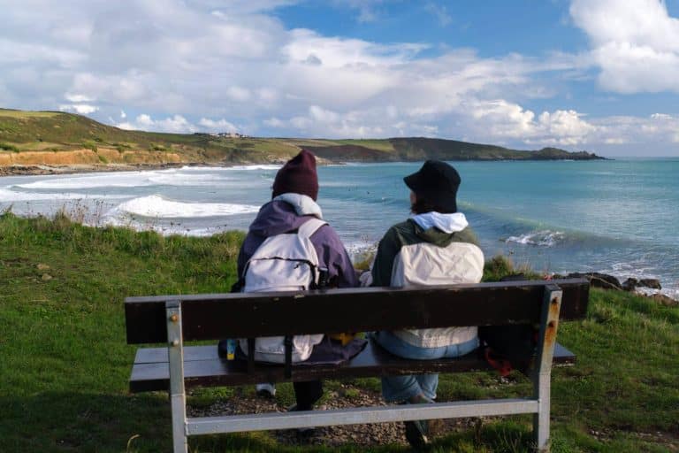 Visitors on a bench at Perranuthnoe Beach Cornwall by Elliot Walker